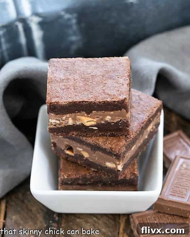 Three Symphony Toffee Brownies in a small square bowl, showing their gooey chocolate center and crisp top.