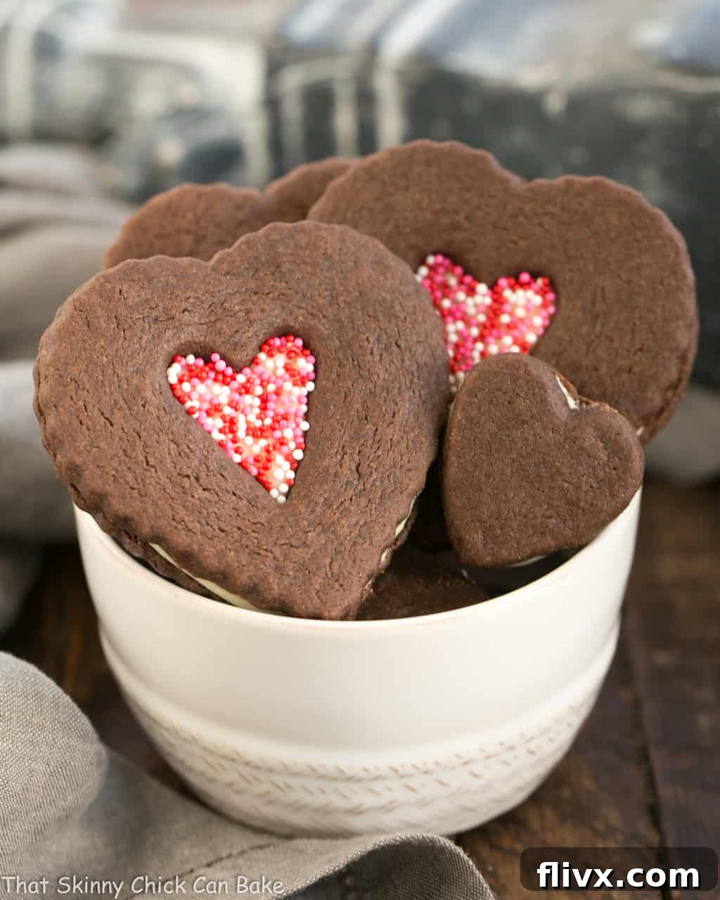 Chocolate Heart Sandwich Cookies artfully arranged in a white bowl, showcasing their delicious filling and festive design.