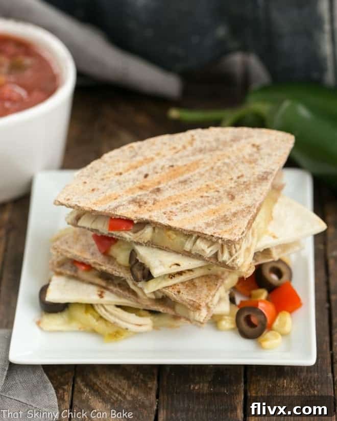 Cheesy Chipotle Chicken Quesadillas on square white plate, cut into wedges.