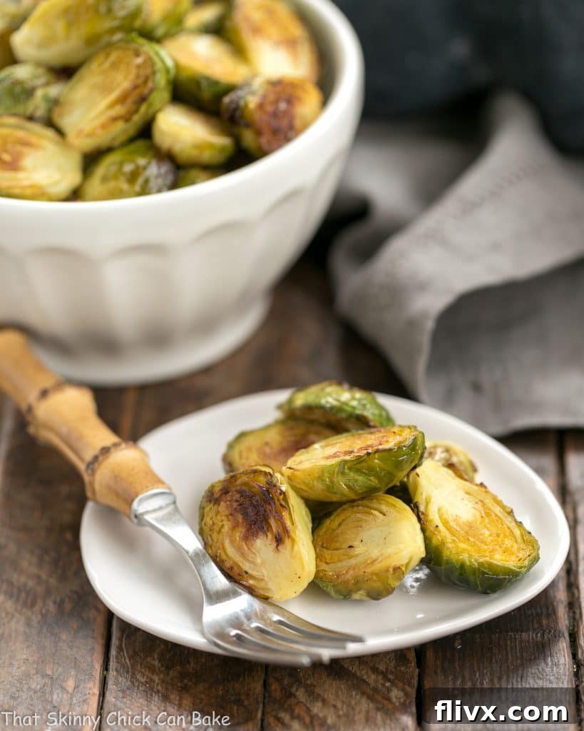 Close-up of a small plate filled with perfectly roasted Honey Mustard Brussels Sprouts, showcasing their caramelized edges and vibrant green color.