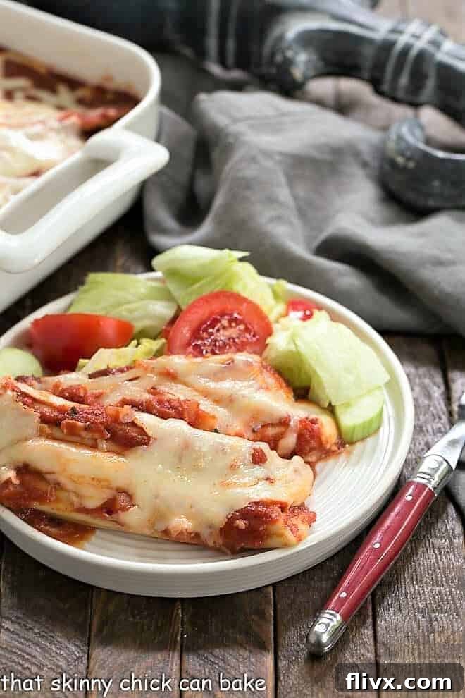 The Best Manicotti on a round white plate with a red handled fork.