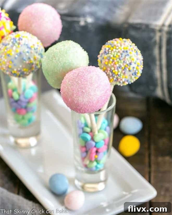 A charming display of Easter Cake Pops, each standing in individual shot glasses on an elegant porcelain tray.