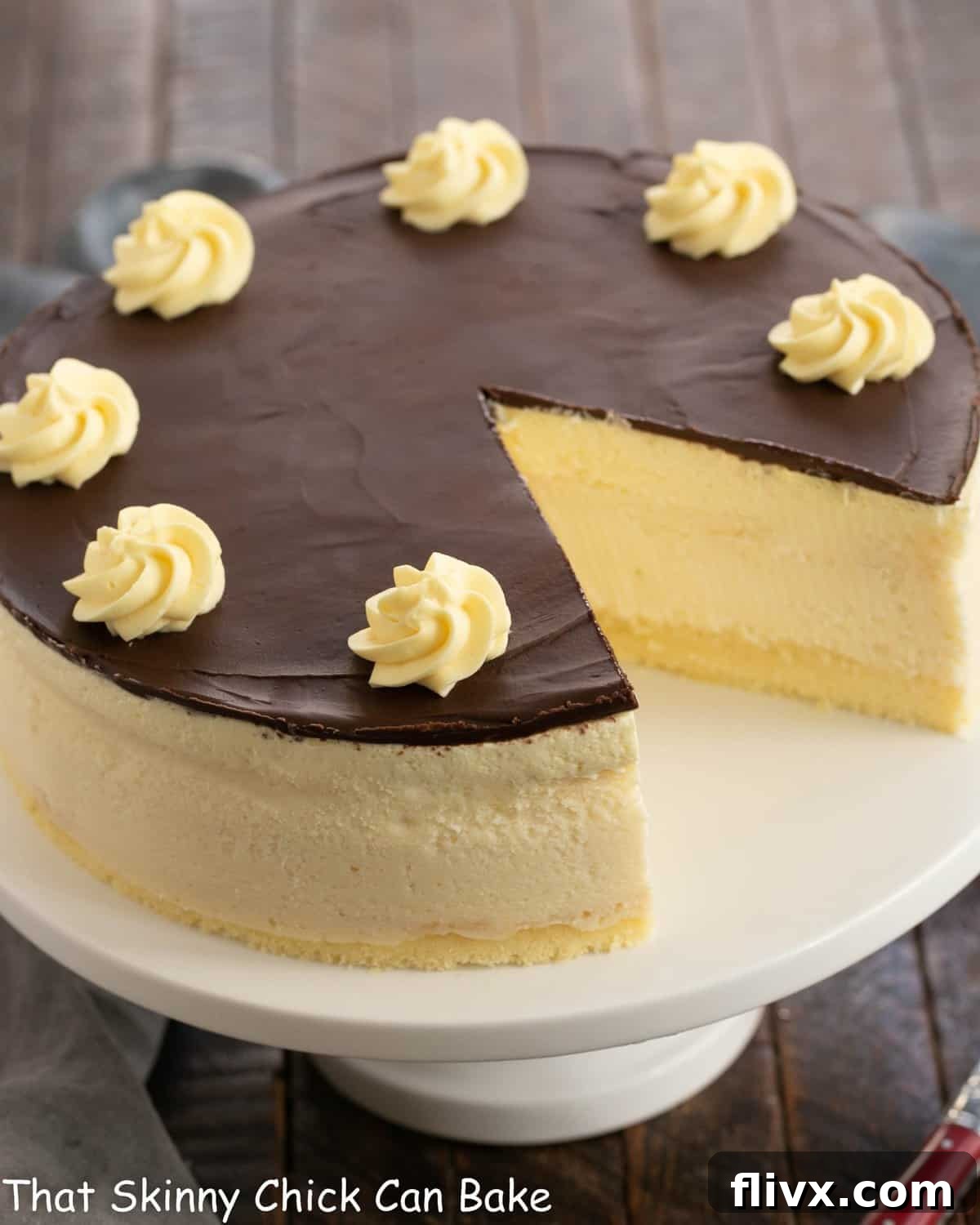 Boston Cream Pie Cheesecake with a slice removed, revealing its beautiful layers.