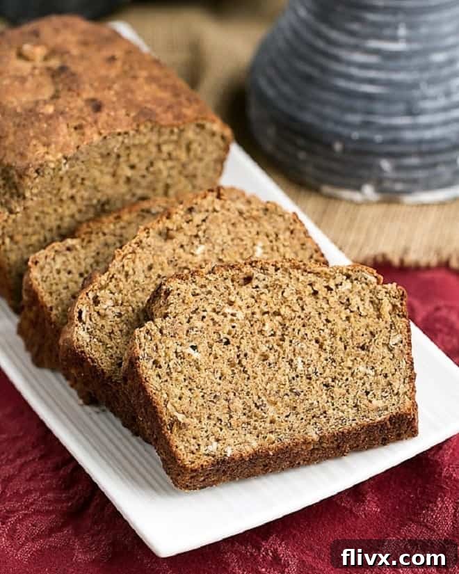 Hearty Irish Brown Bread loaf and rustic slices arranged on a white serving tray, evoking a sense of warmth and home-baked goodness.