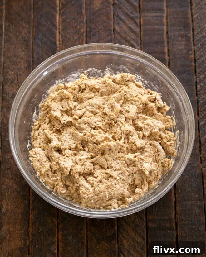 Buttermilk being stirred into the dry and butter mixture to form a soft dough, emphasizing not to overmix.