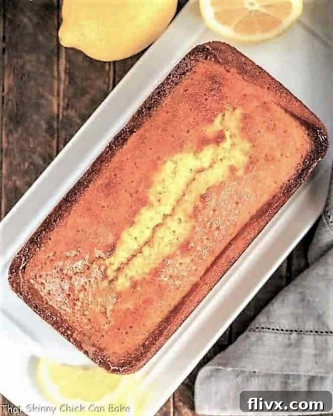 Overhead view of a Glazed Lemon Pound Cake loaf on a white serving tray, showing its perfect golden crust and glistening glaze.