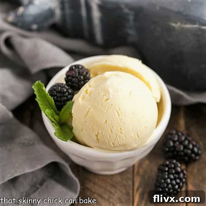 Three generous scoops of creamy White Chocolate Ice Cream served in a white ceramic bowl, adorned with fresh berries and a hint of mint for a refreshing presentation.