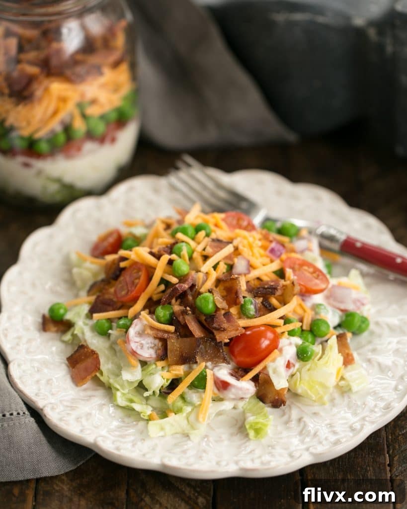 Make Ahead 7-Layer Salads in a Jar removed to a white salad plate, ready to eat