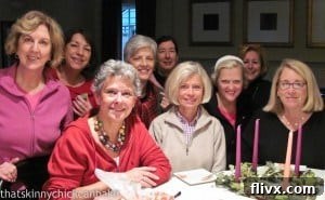 A group of smiling friends enjoying a baking class together in a cozy kitchen setting.