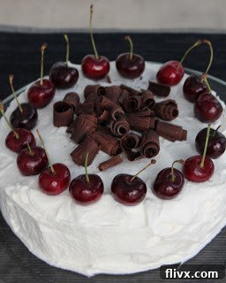 Close-up of Black Forest Gateau layers with cream and cherries