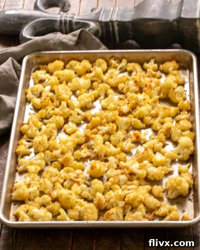 Roasted cauliflower on a sheet pan, tender and browned slightly.