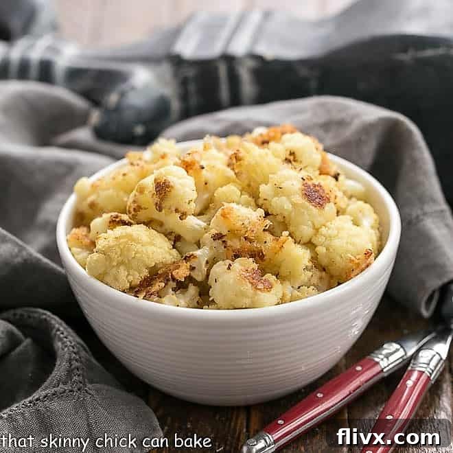 Roasted Cauliflower in a white bowl with two red handled forks