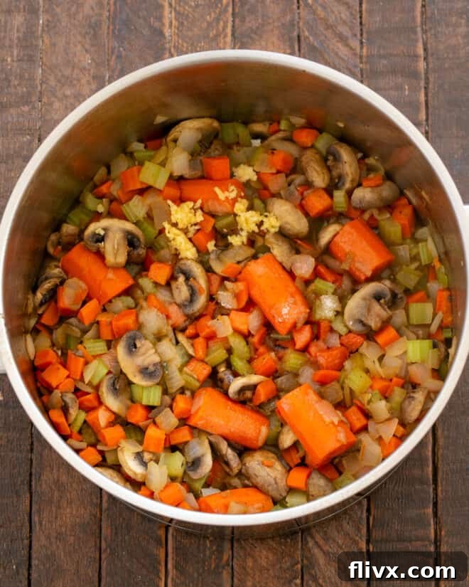 Step 3: Adding sugar and minced garlic to the sautéed vegetables in the Dutch oven, cooking briefly until aromatic.