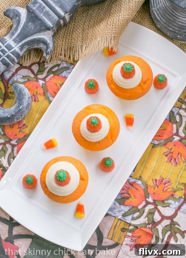 Overhead view of several Candy Corn Cupcakes on a white rectangular plate, showcasing the frosting and candy toppings