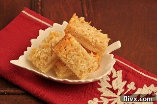 A close-up of Coconut Macadamia Nut Bars nestled in a charming leaf-shaped ceramic bowl, highlighting their rich texture.