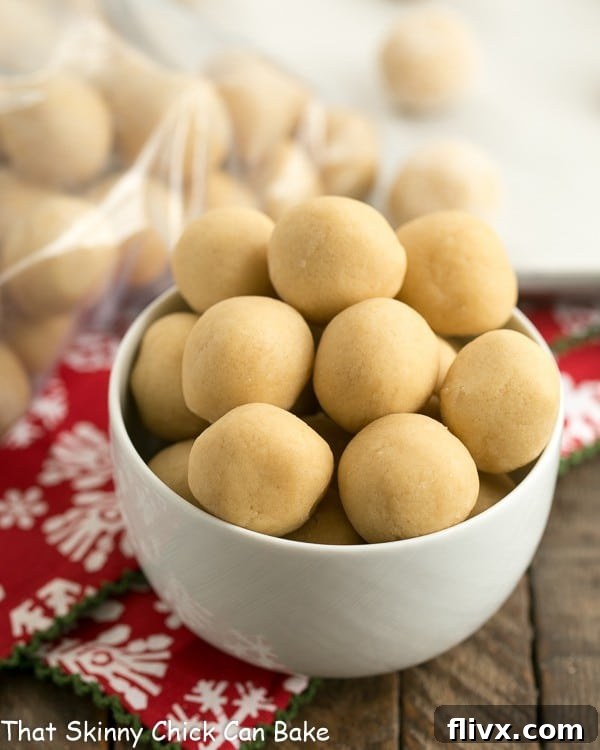 A large bowl brimming with perfectly rounded cookie dough balls, ready to be flash-frozen and stored for future baking.