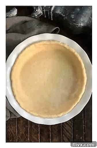 Step 1: An unbaked pie crust neatly fitted into a white ceramic pie pan, ready for filling.
