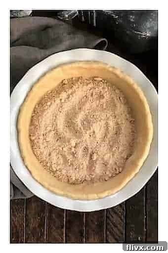 Step 2: A generous layer of homemade crumb topping spread evenly over the bottom of the pie crust.