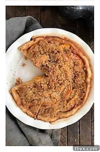 Step 5: A beautifully cooled slice of peach crumb pie, showing layers of crust, peaches, and crumb, ready to be enjoyed.