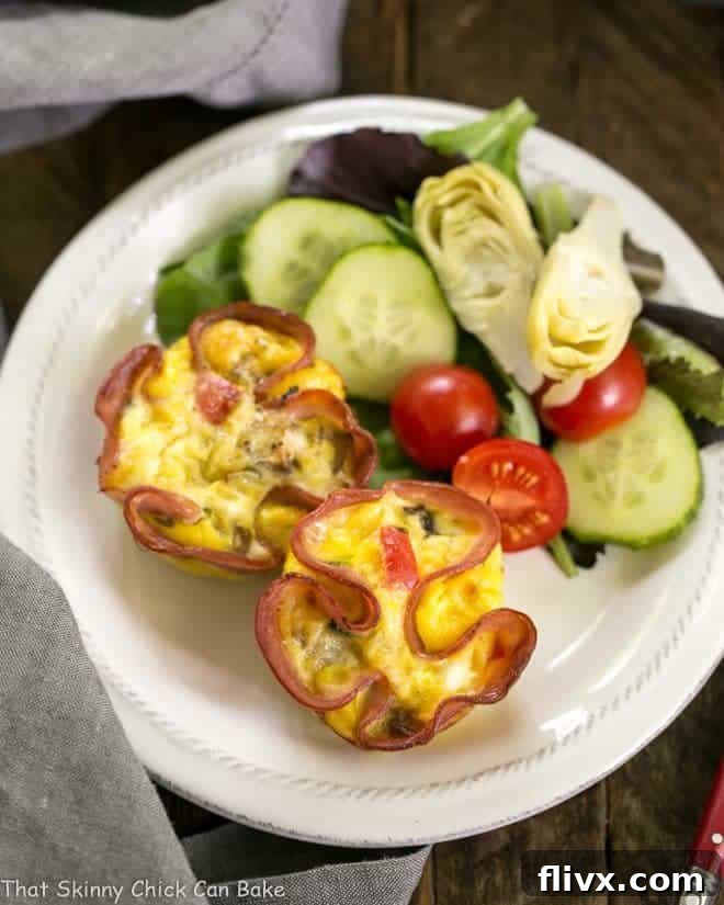 Overhead view of perfectly baked Egg Muffins nestled in ham cups on a small white plate, ready to be enjoyed as a healthy and convenient breakfast.