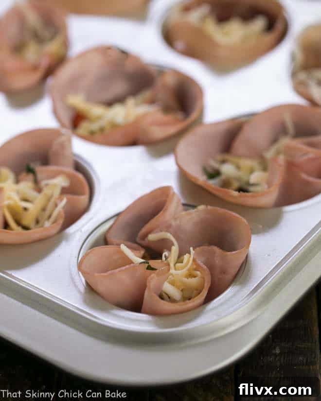 Egg Muffins in ham cups nestled in a muffin tin, perfectly prepped and ready for the oven, showcasing their delicious potential.