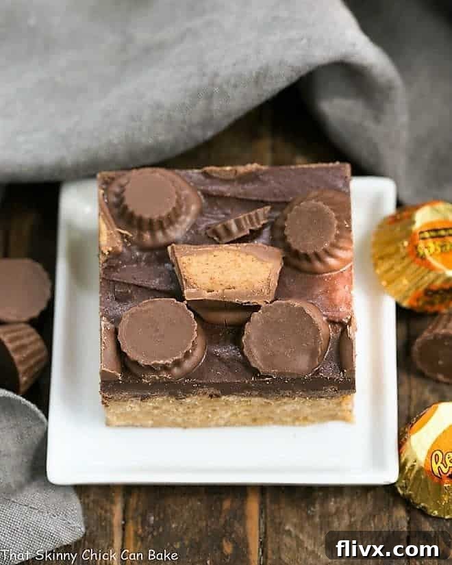 A beautifully presented stack of Reeses Rice Krispie Treats on a small white square ceramic plate, ready to be enjoyed.