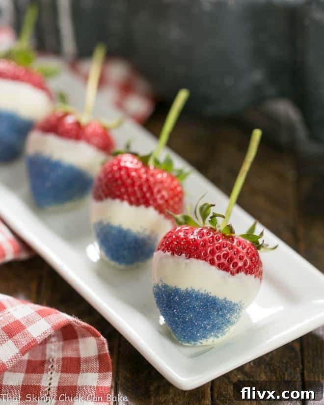 A perfectly arranged line of Red White and Blue Strawberries on a narrow white ceramic tray, showcasing their vibrant colors and festive appeal.