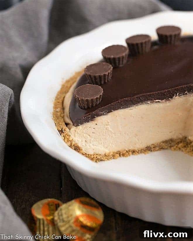 Frozen Chocolate Peanut Butter Pie with slices removed, revealing the creamy layers in a white ceramic pie plate