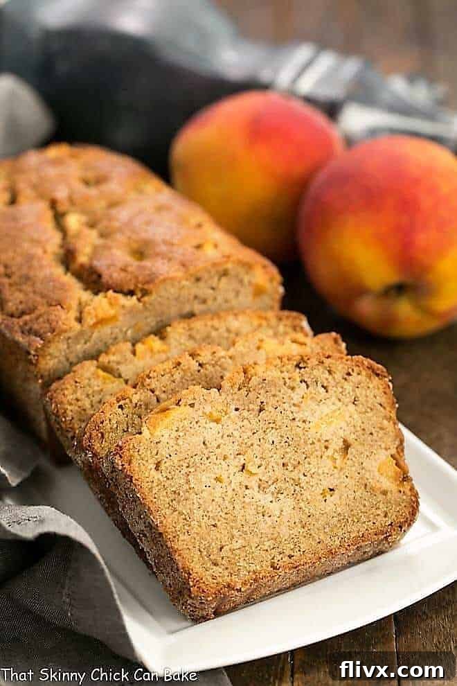 Freshly baked Southern Peach Quick Bread, sliced and arranged on an elegant white rectangular tray, showcasing its tender crumb and abundant peach pieces.