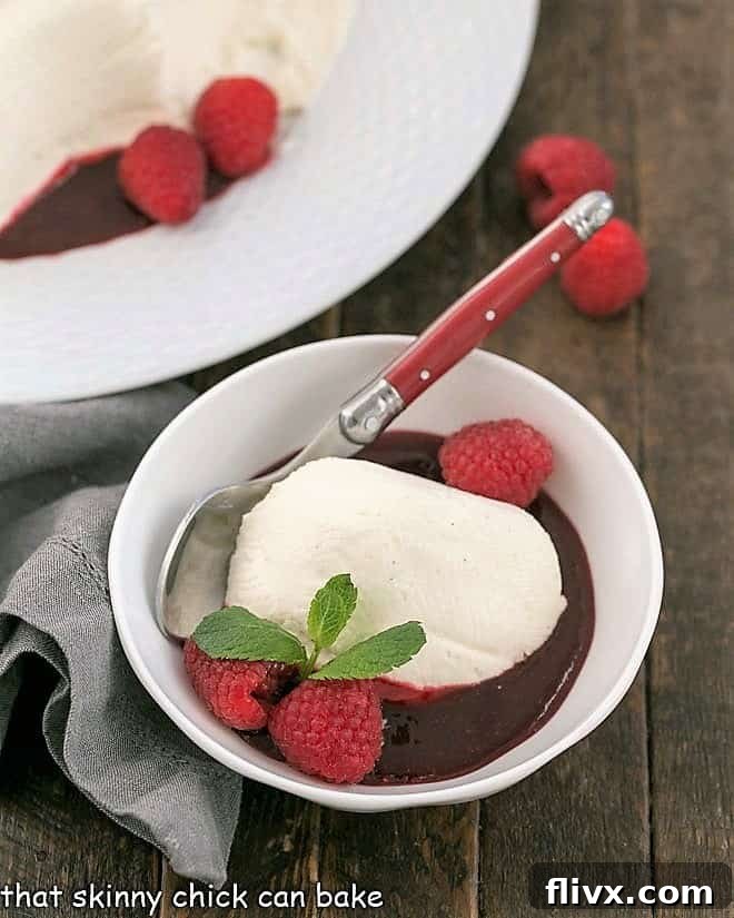 Serving of Coeur a la Creme, a no-bake cheesecake, in a bowl with fresh raspberries and a sprig of mint.