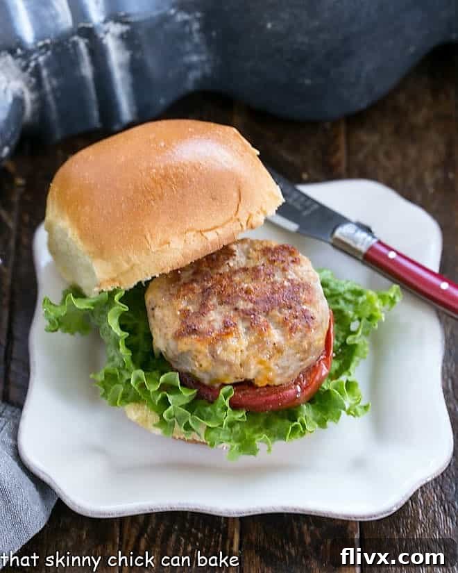A perfectly assembled Turkey Slider with Roasted Tomatoes on a square white plate, ready to be devoured.