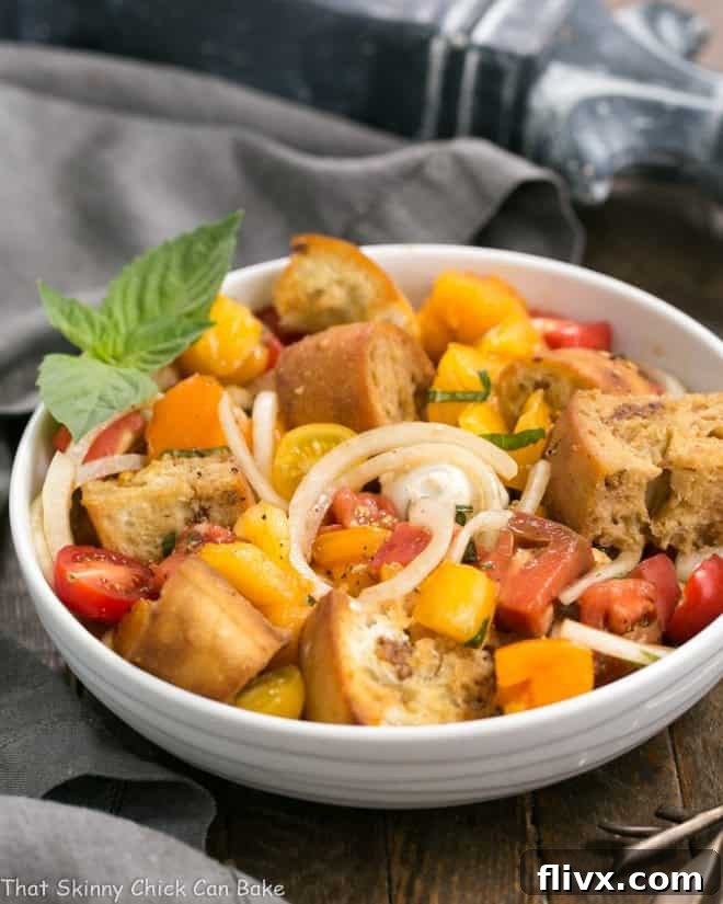 A Summer Tomato and Burrata Panzanella Salad in a white ceramic bowl.