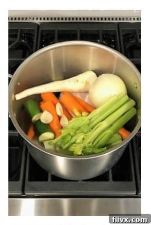 Add fresh vegetables and aromatics to the chicken in the pot.