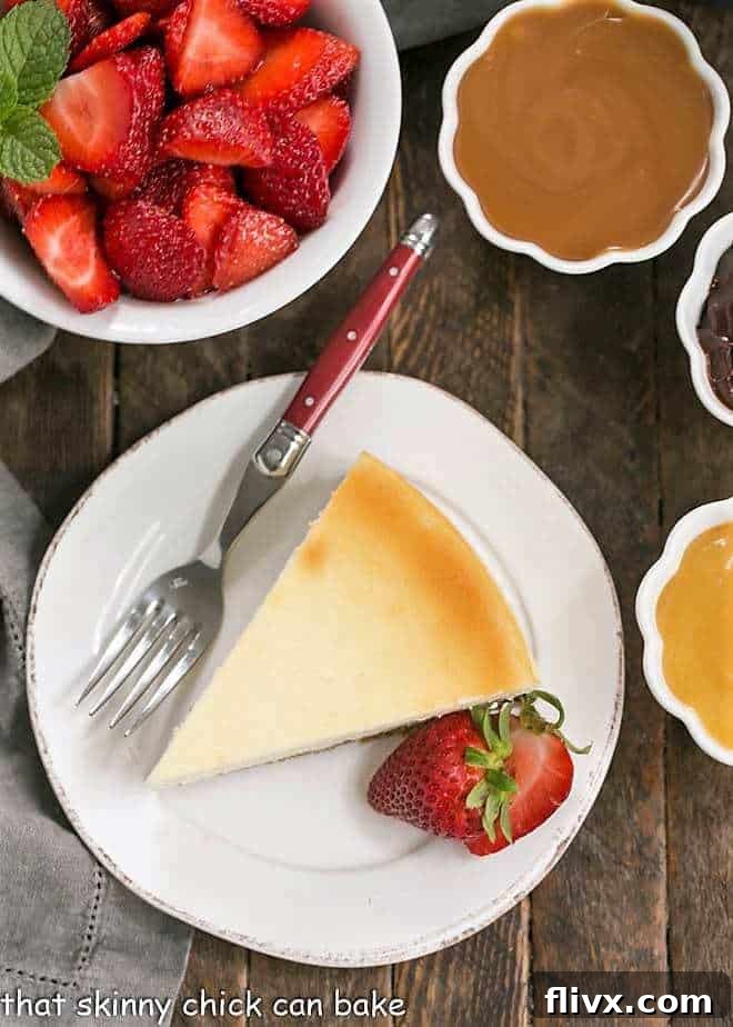 An overhead view of a perfect vanilla cheesecake, artfully surrounded by bowls of fresh strawberries and various tempting toppings.