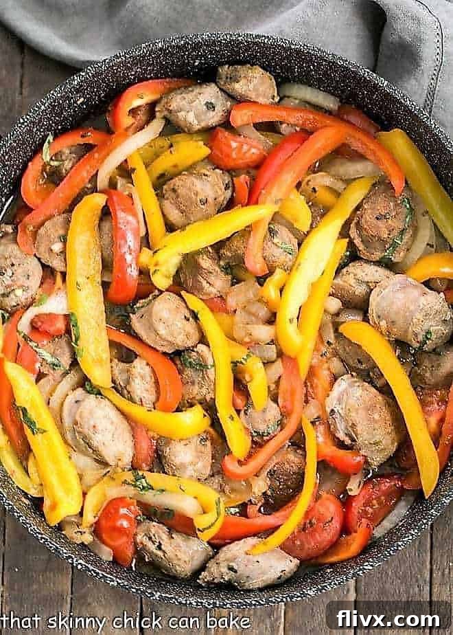 Skillet Italian Sausage and Peppers - a comforting, flavorful meal that's easy to prepare and can be served with Provolone for an unforgettable sandwich! Italian Sausage and Peppers in a black skillet, showcasing vibrant colors and delicious textures