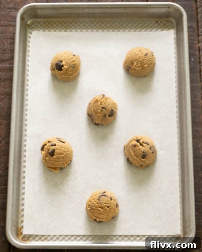 Step 7: Chilling the cookie dough, then rolling it into uniform balls and placing them on a parchment-lined baking sheet.
