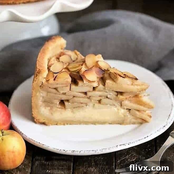 Cream Cheese Apple Torte, sliced to reveal layers of cheesecake and apple pie filling.