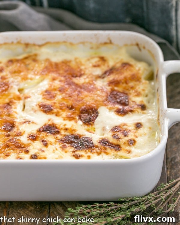 A large baking dish filled with French Potato Gratin, showcasing its bubbling, golden-brown cheese topping and tender potato layers, fresh out of the oven.