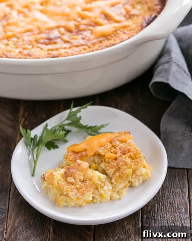 A serving of Easy Sweet Corn Casserole on a small white plate, ready to be enjoyed.