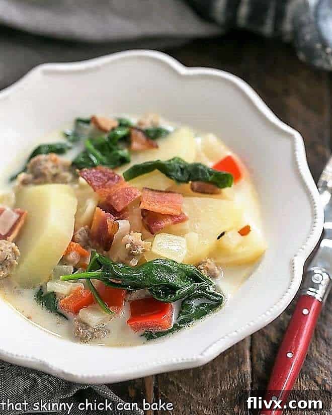 Zuppa Toscana or Tuscan Sausage Soup in a white, ruffle edged soup bowl.