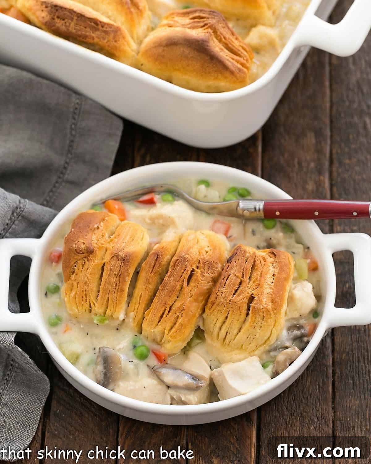 Serving of chicken pot pie in a shallow dish with a red handled fork.