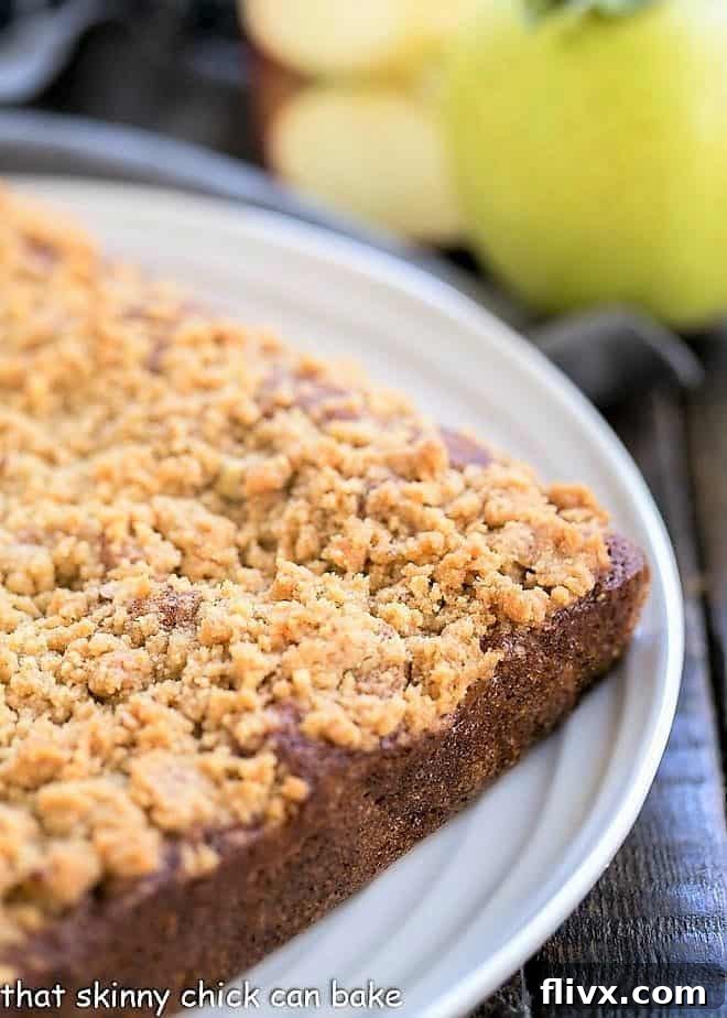 A whole Apple Streusel Coffeecake on a rustic serving platter, showcasing its golden-brown streusel topping.
