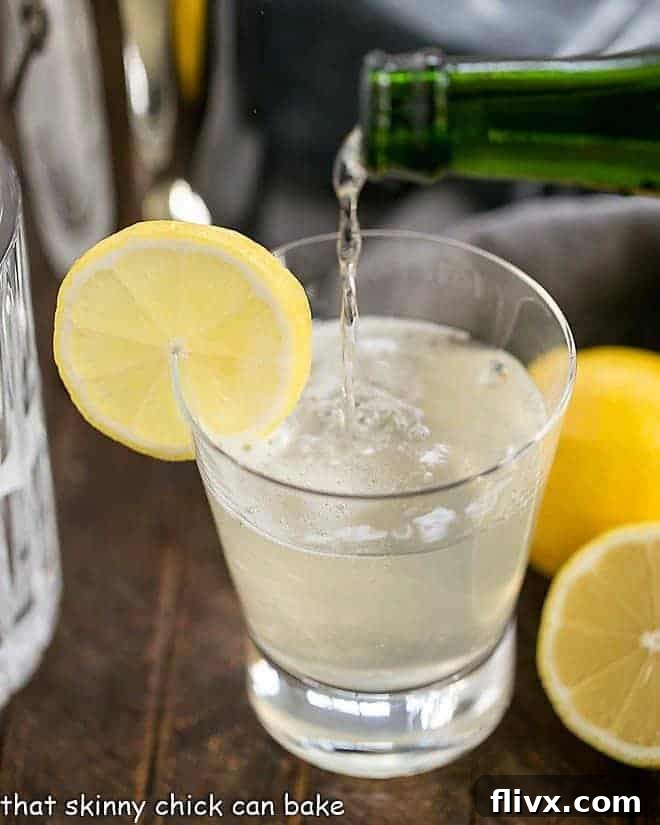 A French 75 Champagne Cocktail elegantly garnished with a fresh slice of lemon, ready to be enjoyed.