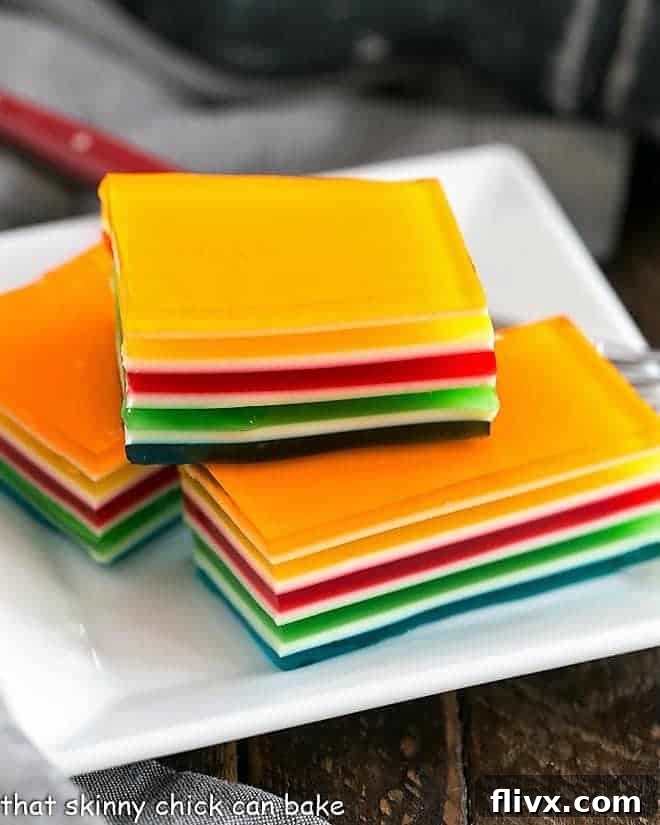 Jello Rainbow Ribbon Salad slices on a square white plate, showing layers
