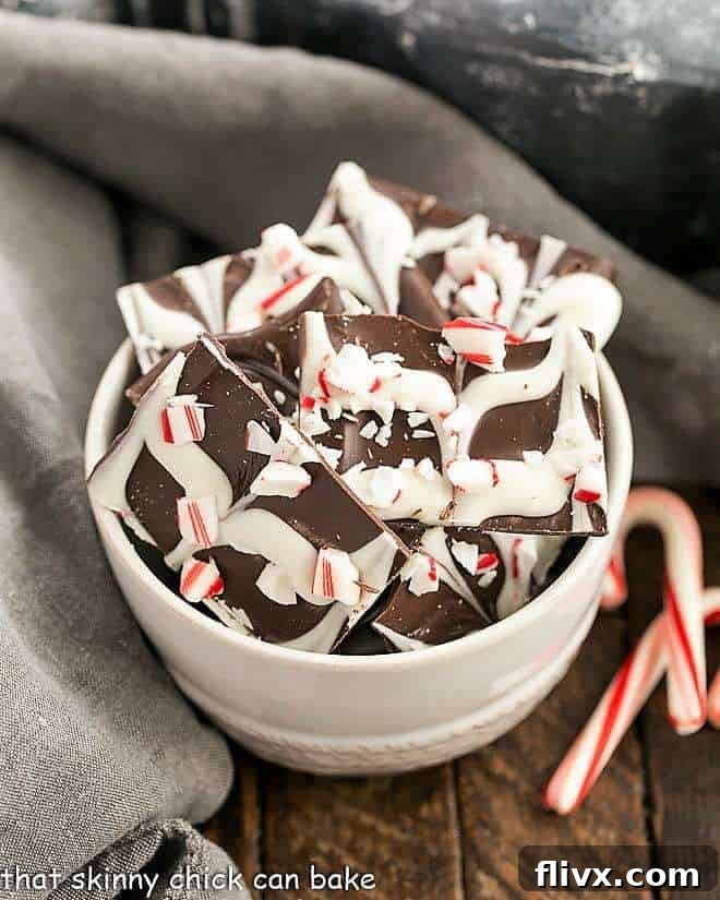 Swirled Peppermint Bark in a white bowl with candy canes