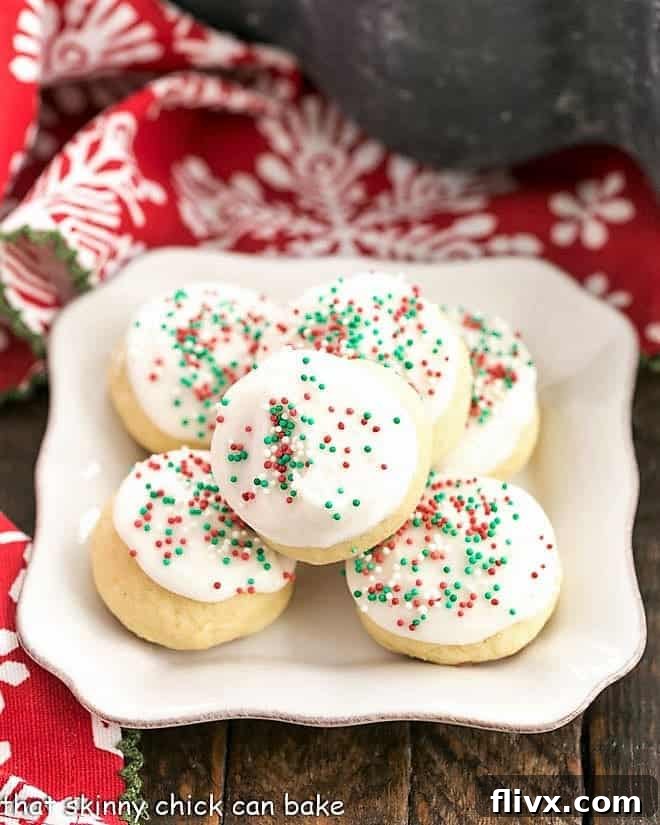 Frosted Italian Ricotta Cookies arranged on a square white plate, adorned with colorful sprinkles, showcasing their tender texture.