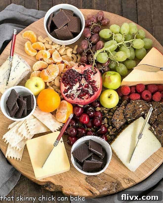 Chocolate Dessert Board - an elegant way to end a meal with top notch chocolates, fruit and cheeses artfully displayed for a jaw dropping presentation! An elegant overhead shot of a Chocolate Dessert Board, featuring assorted chocolates, fresh fruits, artisanal cheeses, and nuts arranged beautifully on a rustic wooden board.