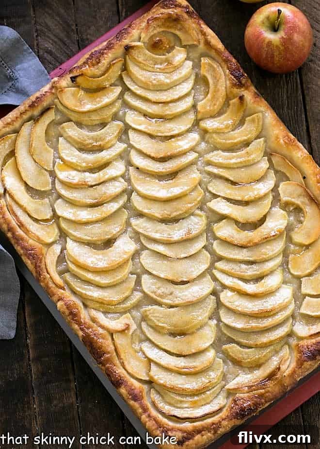 Overhead view of a beautifully presented platter of Easy, buttery French Apple Tart, sliced and ready for guests.