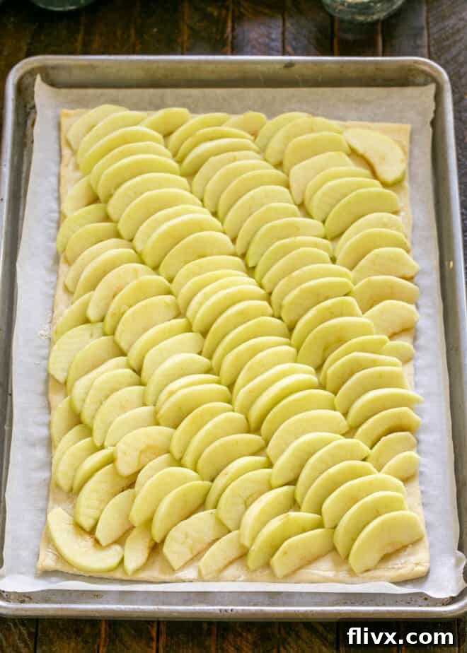 Step 3: Arrange apple slices meticulously in an overlapping pattern on the puff pastry base.
