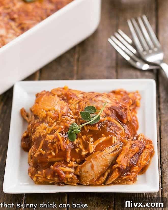 Easy Turkey Enchilada Casserole served on a white ceramic plate with forks, showing layers of tortillas, turkey, and melted cheese.